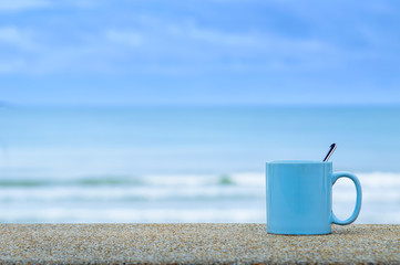 Fototapeta na wymiar blue cup on the beach with blue sea and sky