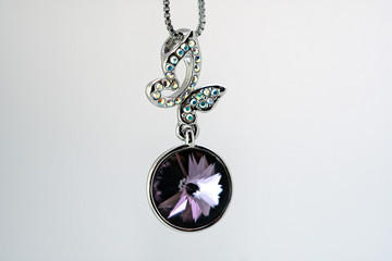 Beautiful jewerly with big violet dimond and silver butterfly above