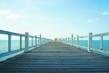 Fototapeta na wymiar White wooden bridge stretching to the sea in sunny day.Feeling freedom with love.