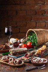 a lot of different dishes on the holiday table. Georgian Cuisine, roasted meet, greens, vegatables, barbeque, red sauce.