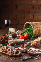 a lot of different dishes on the holiday table. Georgian Cuisine, roasted meet, greens, vegatables, barbeque, red sauce.