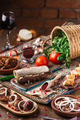 a lot of different dishes on the holiday table. Georgian Cuisine, roasted meet, greens, vegatables, barbeque, red sauce.