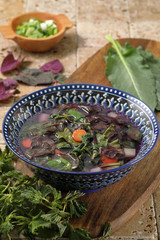 zuppa di verdure spontanee su tavolo di pietra rustico