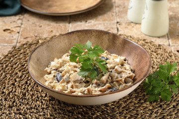 insalata di pollo con funghi in piatto di ceramica su tavolo di pietra rustico