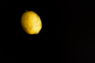 One isolated lemon on a black background. Natural ripening fruit. Unselected, natural looking....