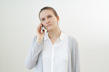 Calm, unemotional woman talks on phone, listens to other person, does not react.