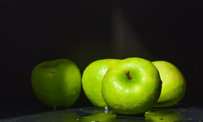 ripe green apples are covered with water drops
