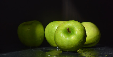ripe green apples are covered with water drops