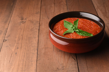 Spanish tomato cold gazpacho soup in bowl with basil. Homemade gazpacho prepared by red tomatoes. Copy space.