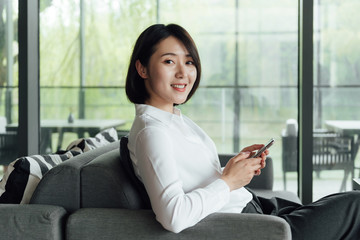 An Asian business woman with short hair is working