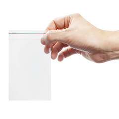 Plastic transparent ziplock bag in hand, isolated on white background