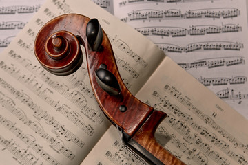 Close up of cello scroll with sheet music