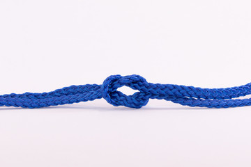 Blue string twisted and knotted against a white background