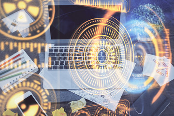 Computer on desktop in office with technology theme hologram. Multi exposure. Tech concept.