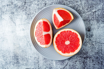 Red grapefruit with slaces and mint leaves on a light background