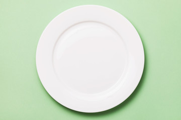 White plate on a green background, top view. Food background