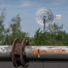Close-up of a tube at Landscape Park Duisburg North, in the backgroud the famous wind wheel