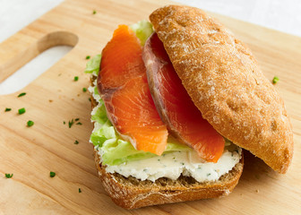 salmon sandwich with brown bread, dill cheese, and iceberg lettuce