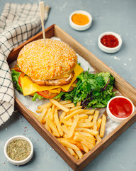 chicken burger with french fries on wooden board