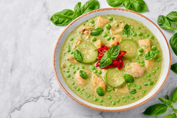 Thai Green Curry with Chicken or Gaeng Kaew Wan Gai on white marble background. Thai Green Curry is a Thailand cuisine dish with green chillies, basil, coconut milk, vegetables and spices.
