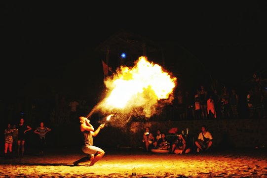 Side View Of Male Fire-eater Performing At Beach During Night