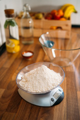 Flour to an electronic weight to make pizza dough in in home kitchen