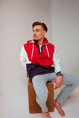 Modelo chaqueta deportiva sentado en estudio