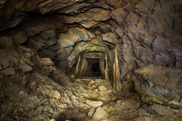 Abandoned copper ore mine underground tunnel with collapsed wooden timbering