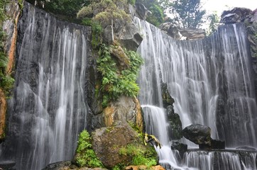 Low angle shot of a beautiful artificial waterfall at Longshan temple in Taipei, Taiwan