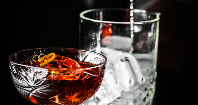 Dark cocktail with zest on dark background