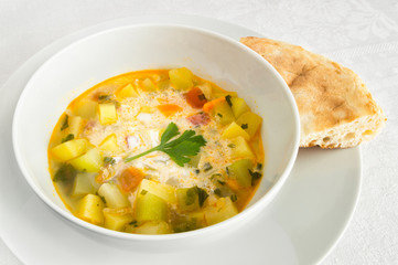 potato, courgette, tomato, carrot, onion, and parsley soup with sour cream served with pita