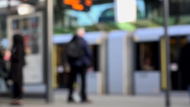 Abstract defocused view of people in city of Manchester by trams England UK 4K
