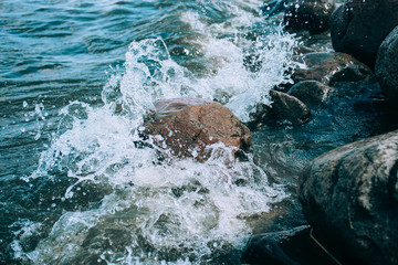 Fototapeta premium stormy weather, a wave beats on a stone