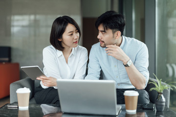 Two young Asian business men and women are working