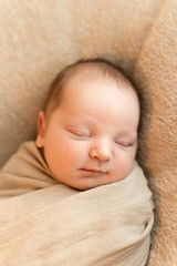 Close up of swaddled newborn baby sleeping peacefully