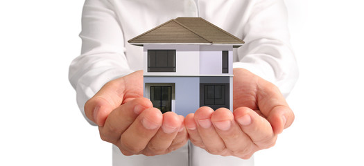 Mortgage concept by money house. holding  house model in hand