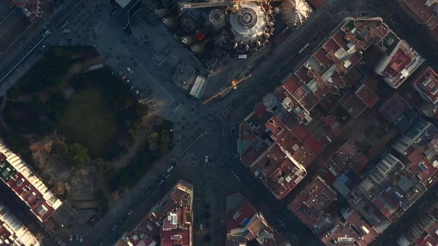 AERIAL: Barcelona Overhead Drone Shot of Typical City Blocks and La Sagrada Familia in Beautiful Sunlight with Urban Traffic 