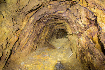Abandoned copper ore mine underground tunnel with yellow dirt