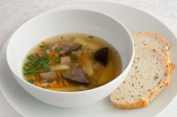 brown birch bolete soup decorated with green onion served with bread