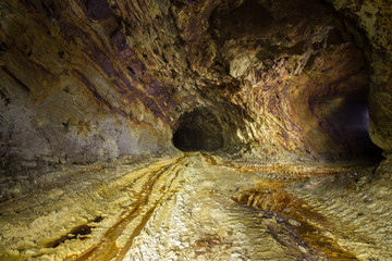Abandoned copper ore mine underground tunnel with yellow dirt