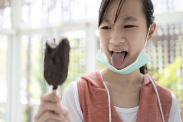 Sick asian child girl having problems with taste of ice cream,loss of taste and impaired sense of tasting food,symptoms of infectious disease,ill,cold,flu,disgusting with tongue out of mouth,bad taste