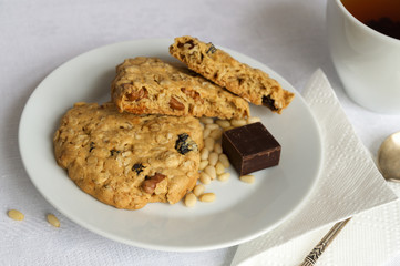 oat cookies with pine nuts and chocolate served with a cup of tea
