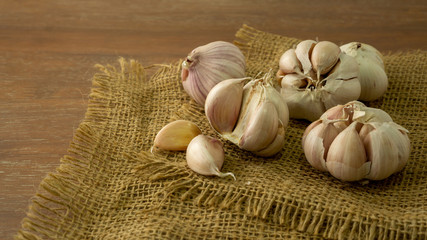 A pile of white garlic cloves and bulb peeled on vintage sack, a good food condiment vegetable for health and medicine