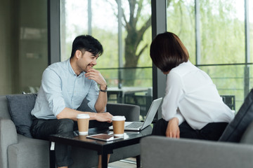 Two young Asian business men and women are working