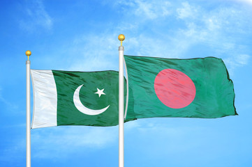 Pakistan and Bangladesh two flags on flagpoles and blue cloudy sky