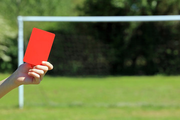 hand holding a soccer red card 