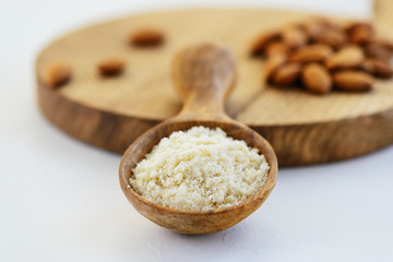 Almond flour in a wooden spoon on a wooden board. Healthy food, gluten free.