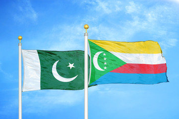 Pakistan and Comoros two flags on flagpoles and blue cloudy sky