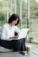 An Asian business woman with short hair is working