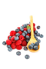 Fresh blueberries and raspberries with a wooden spoon